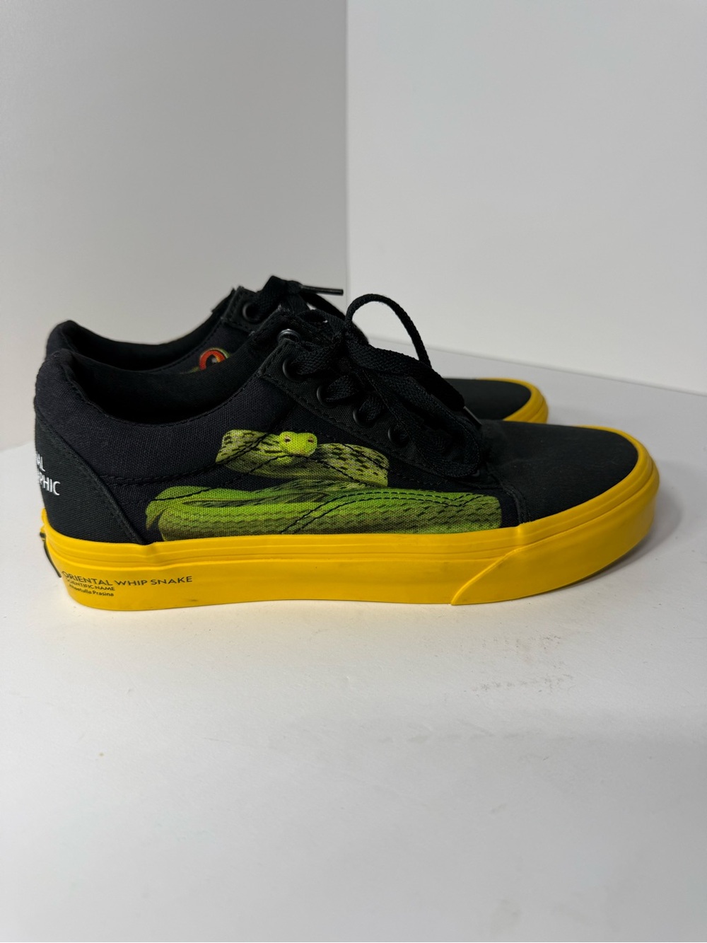 Vans Black Canvas Sneakers with Yellow Midsole and Green Snake Graphic.
